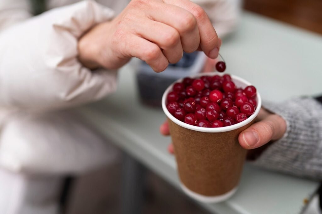 Glass of cranberry juice with fresh cranberries, perfect for a diabetic-friendly diet in moderation