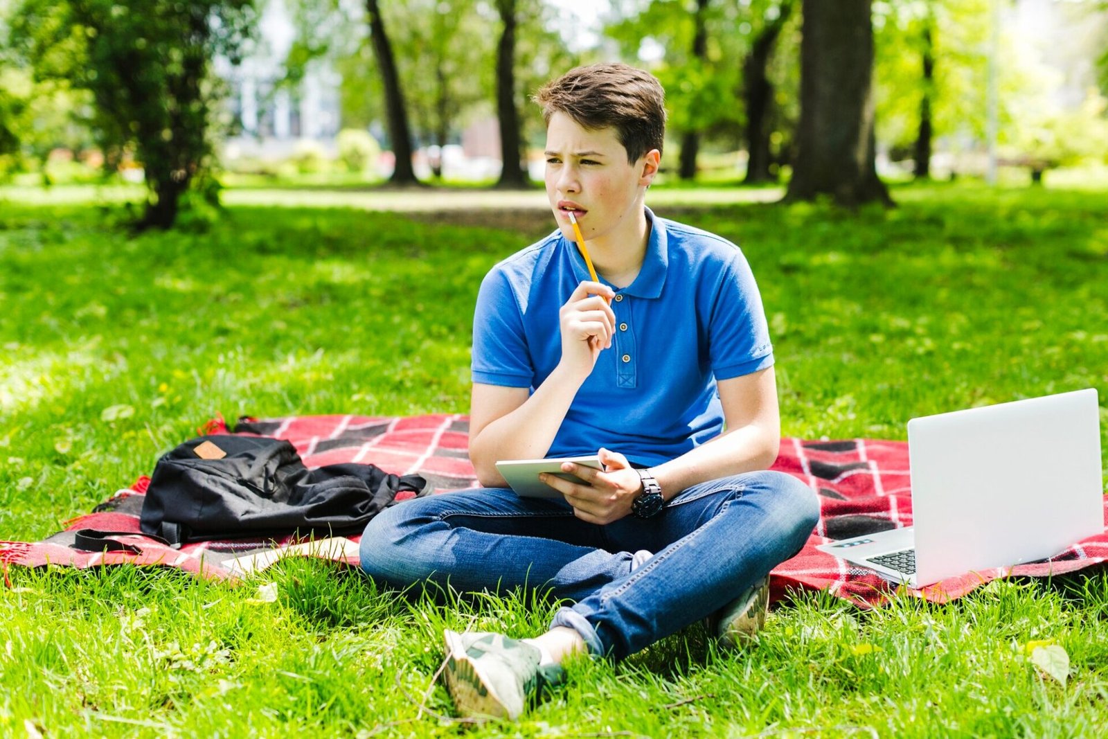 Person sitting outdoors with a notebook, practicing stress relief in nature