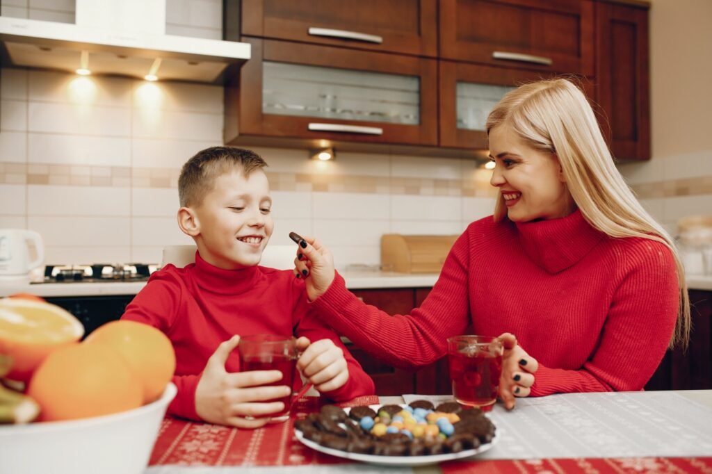Mother pouring cranberry juice into a child’s bowl of oatmeal